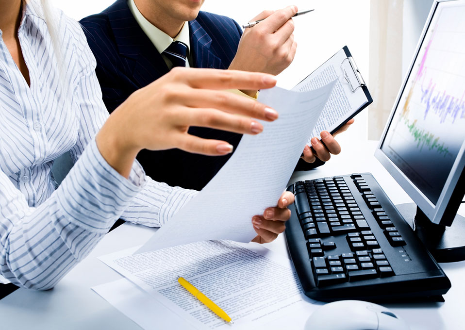 two office workers looking at a graph on a computer